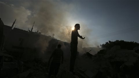 Un Palestinien se tient sur les décombres d'une maison qui aurait été détruite par un tir israélien, à Gaza.