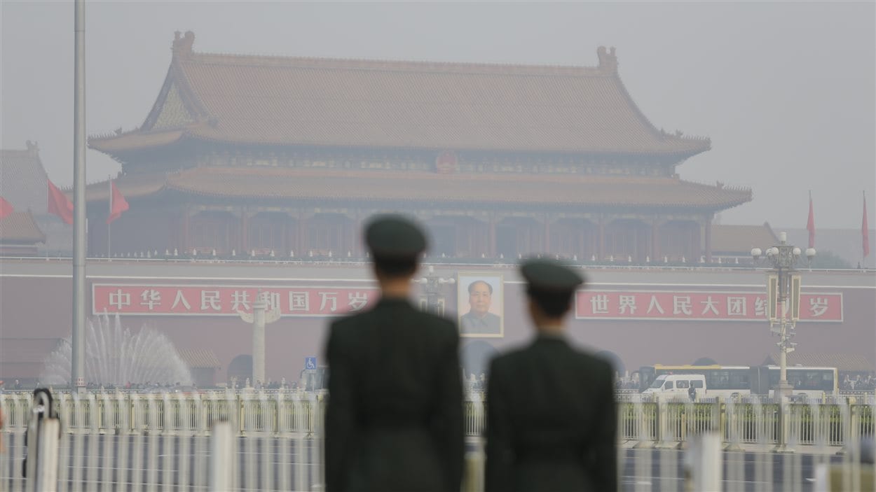 Des policiers près de la Place Tiananmen, un jour de smog, à Pékin.
