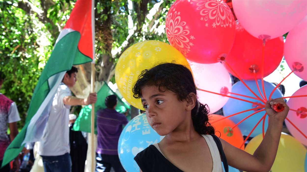Une jeune palestinienne vend des ballons dans le cadre d'une manifestation d'appui au Hamas qui a eu lieu jeudi à Gaza.