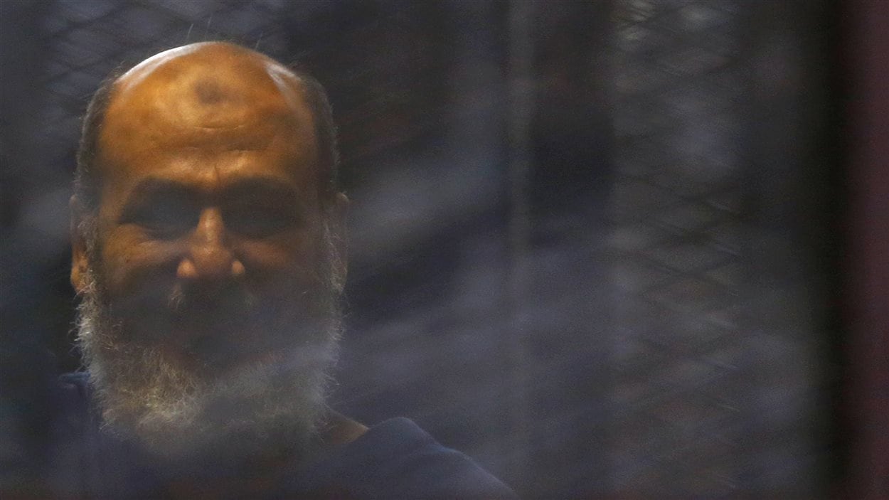 Le clerc islamiste Safwat Hegazis derrière les barreaux d'une salle d'audience au Caire, le 7 août 2014
