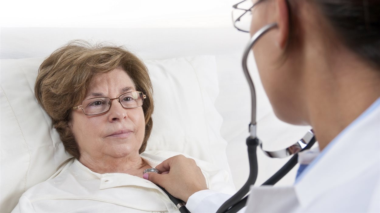 Une femme est ausculté par un médecin