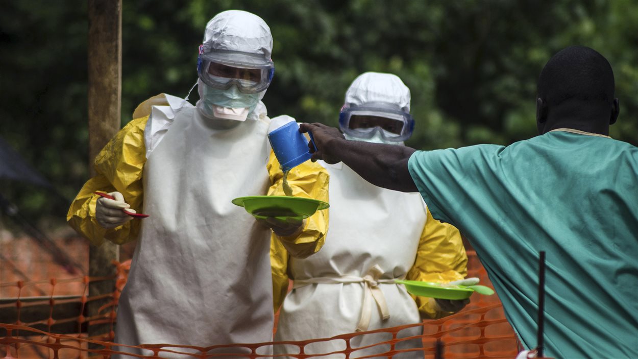 Du personnel de Médecins sans frontières apporte de la nourriture à des patients placés en isolation en raison du virus de l'Ebola, en Sierra Leone.
