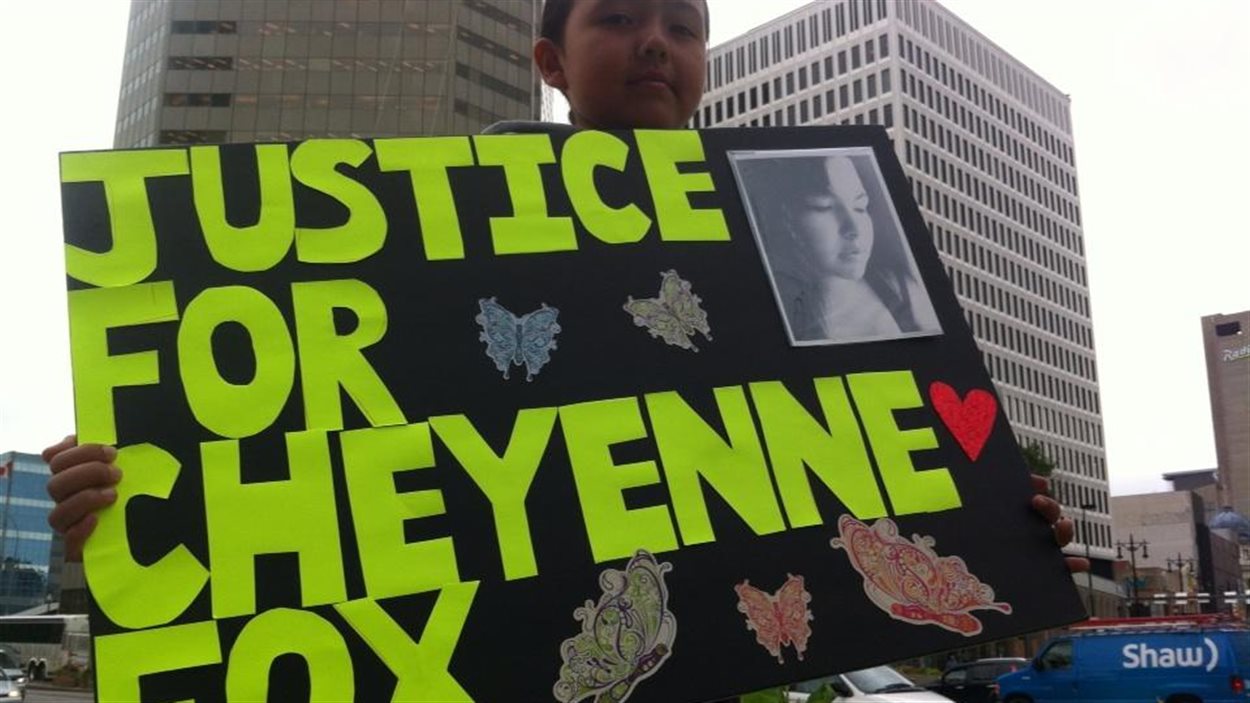 Le jeune Cedar Mainville tient, le 22 août 2014, une pancarte pour sa tante Cheyenne Fox. Celle-ci est morte après une chute d'un balcon en avril 2013. La police de Toronto a conclu à un suicide, ce que conteste la famille.