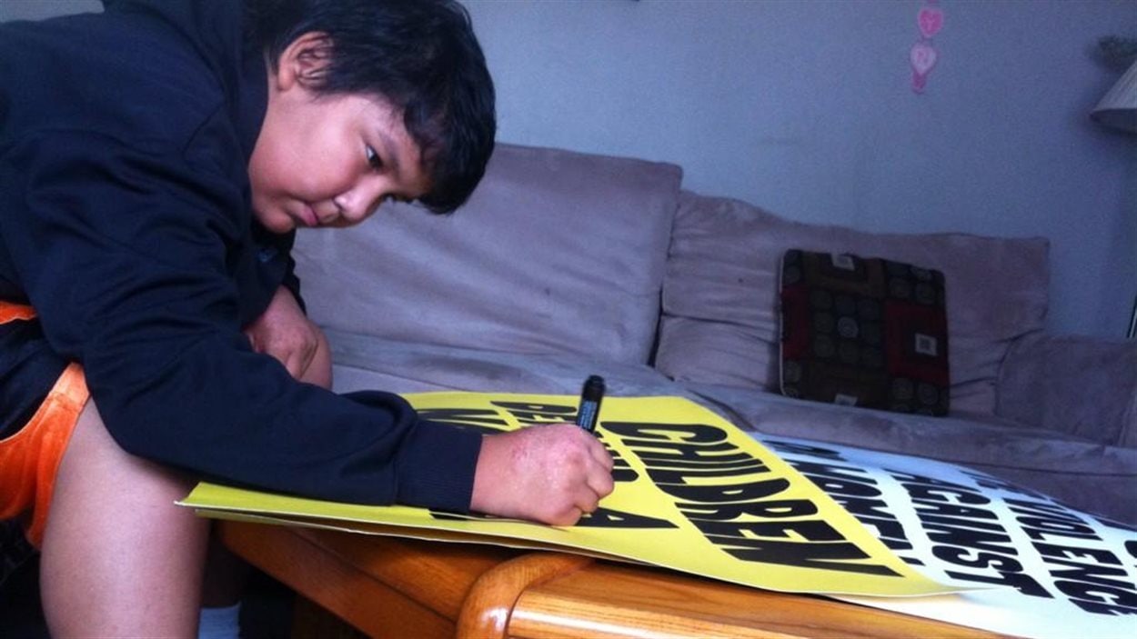 Le jeune Kendal Wood, 14 ans, prépare ses pancartes pour la manifestation en faveur d'une enquête nationale sur les femmes autochtones disparues ou assassinées à Winnipeg, le 22 août 2014.