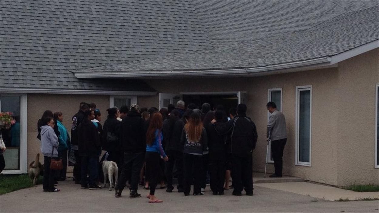 Les gens entrent dans l'église de la Première Nation de Sagkeeng au Manitoba pour les funérailles de Tina Fontaine, le 23 août 2014.