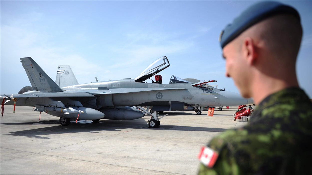 Un soldat canadien regarde un CF-18, à Trapani, en Italie (archives 2011).