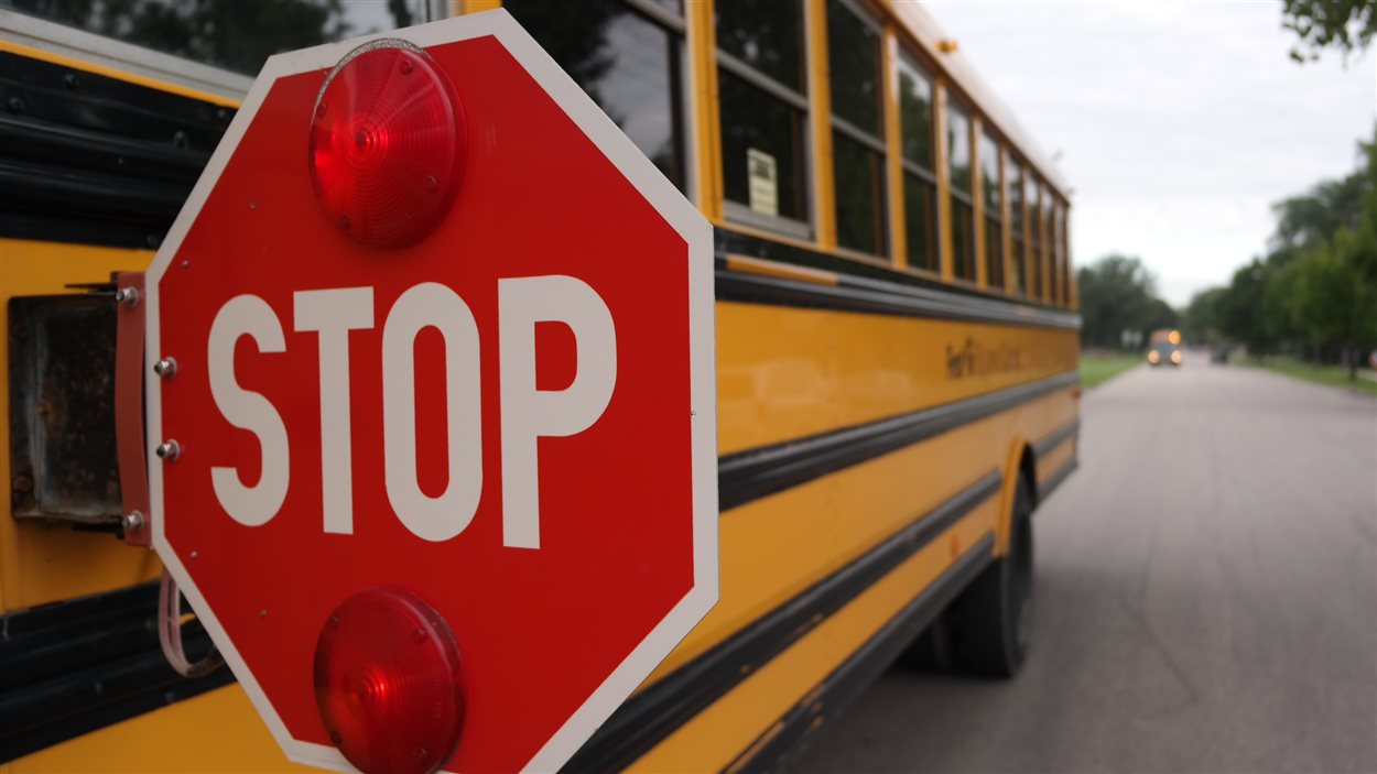 Un autobus scolaire fait son premier arrêt au Collège Louis-Riel lors de la rentrée scolaire 2014.