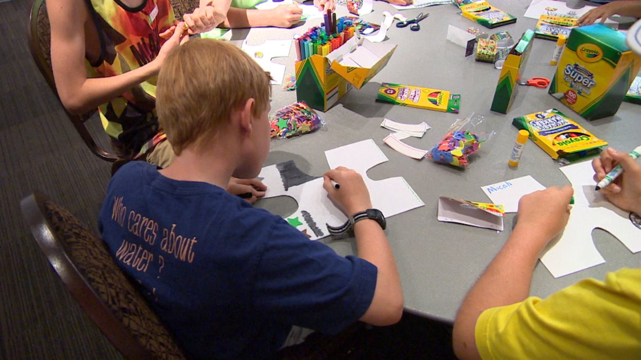 Des enfants fabriquent un casse-tête dans le cadre d'une activité organisée par le Musée canadien pour les droits de la personne.
