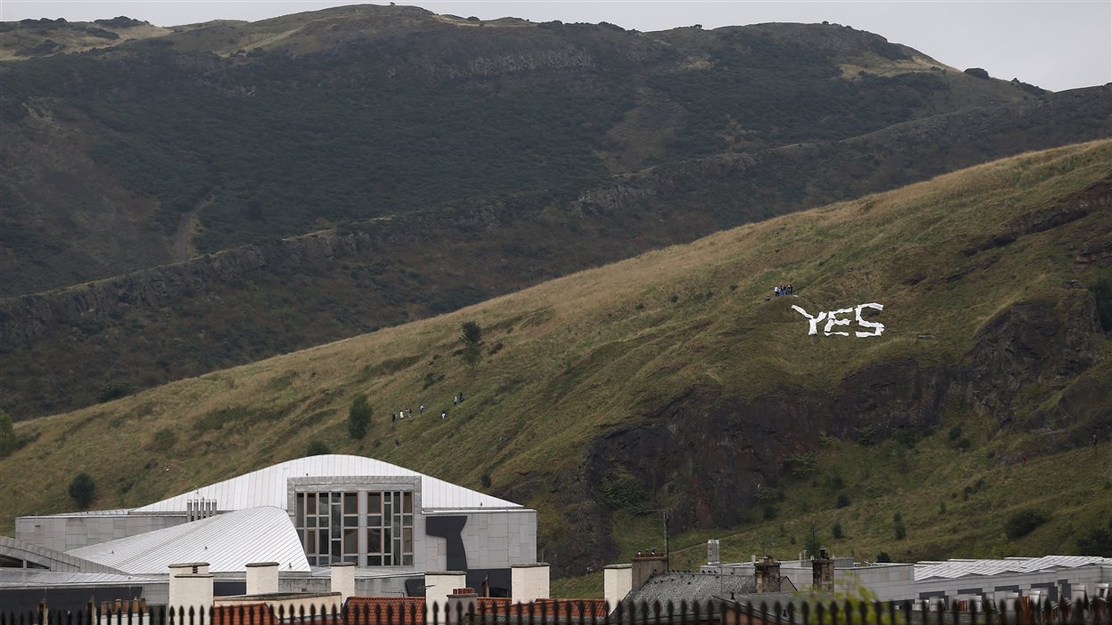 Un signe « oui » est installé sur une montagne qui surplombe le parlement écossais à Édimbourg.