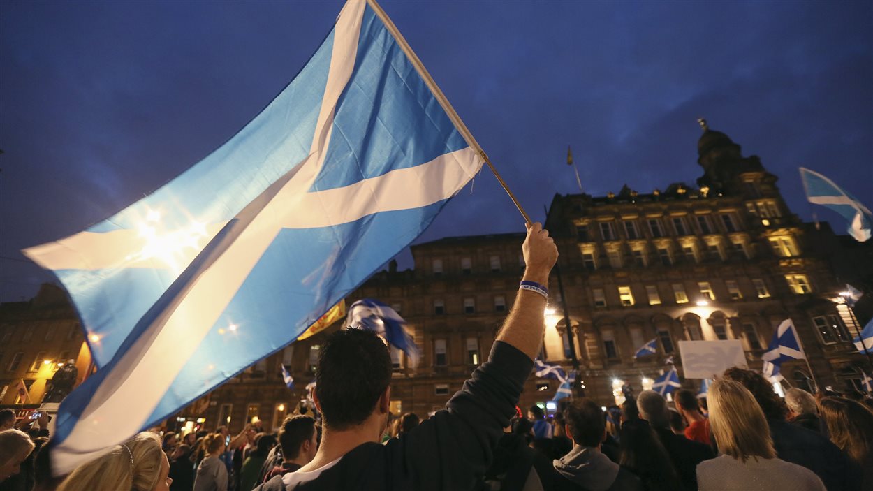 Un partisan du oui brandit un drapeau pendant un rassemblement à Glasgow, la veille du scrutin.