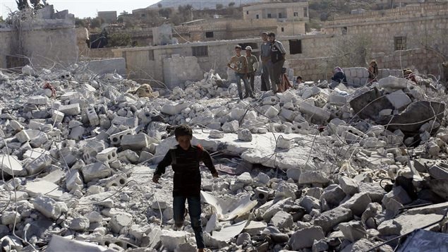 Des résidents de Kfredrian, en Syrie, regardent les dégâts, après les raids américains contre le groupe armé État islamique. 