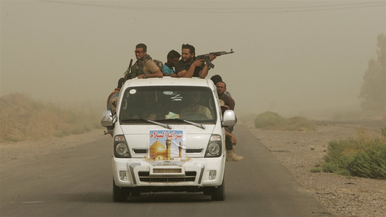 Des combattants chiites irakiens avec la patrouille « Brigades de la paix » durant une tempête de sable à Samarra, en Irak, le 12 juillet dernier