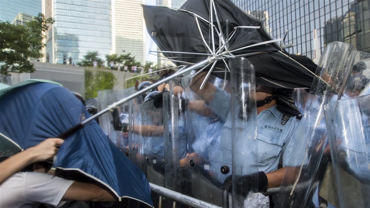 Des étudiants prodémocratie à Hong Kong tentent de se protéger contre le gaz poivré que leur aspergent les policiers. 