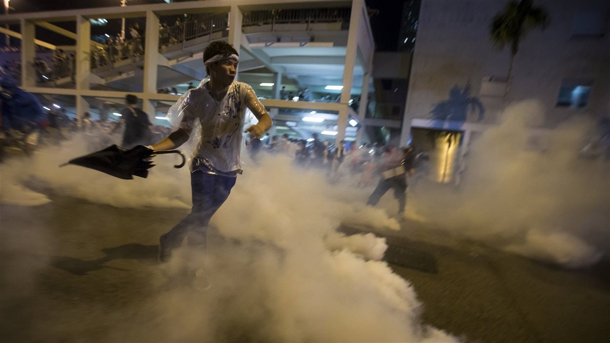 Un manifestant défie la police antiémeute qui a eu recours aux gaz lacrymogènes.