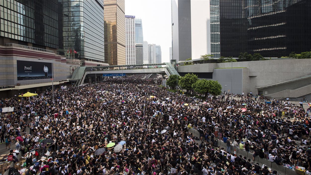 Des manifestants bloquent la rue principale du quartier des affaires de Hong Kong.