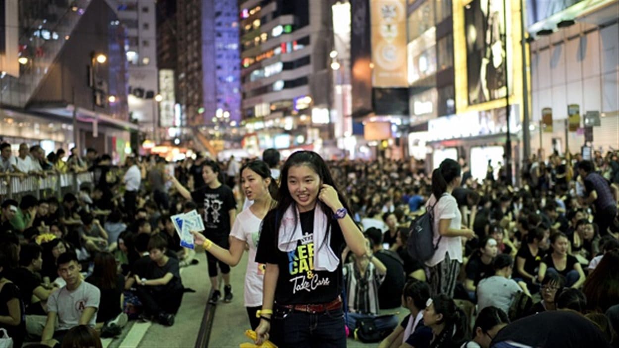 Deux jeunes manifestantes circulent parmi les autres protestataires déterminés à défier les autorités.