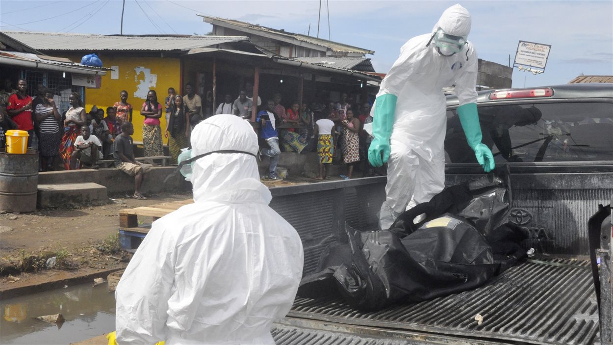 Des travailleurs de la santé transportent le corps d’une victime présumée du virus Ebola, près de Monrovia, au Liberia, le 1er octobre 2014.