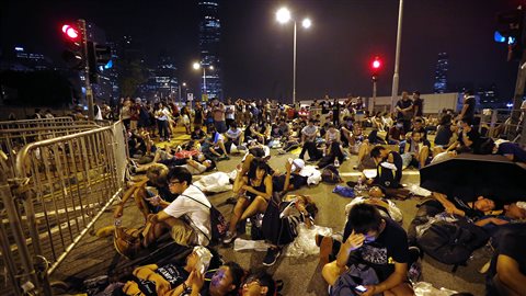 Des manifestants dorment à la sortie d'un édifice gouvernemental de Hong Kong
