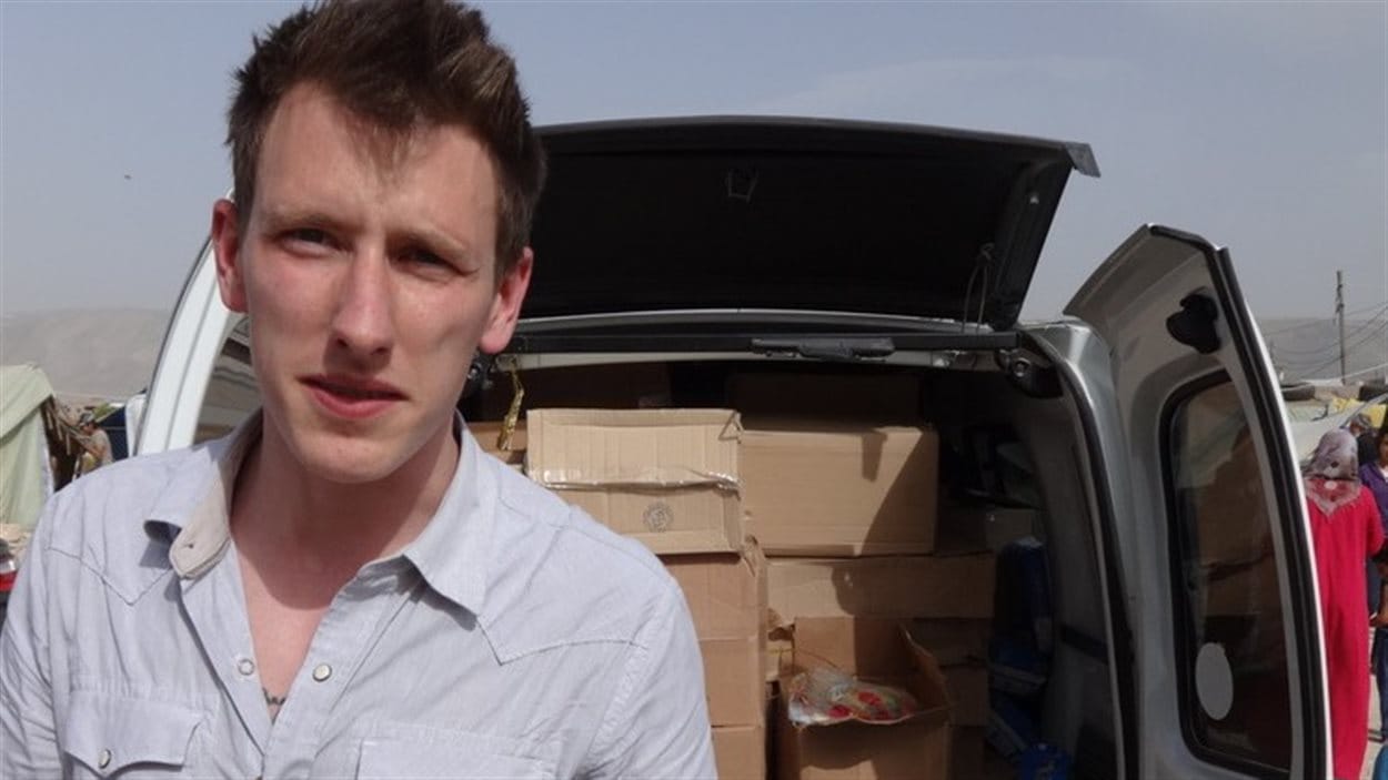 Une photo de Peter Kassig fournie par ses parents le montrant debout près d’un véhicule plein d’effets destinés aux réfugiés syriens.