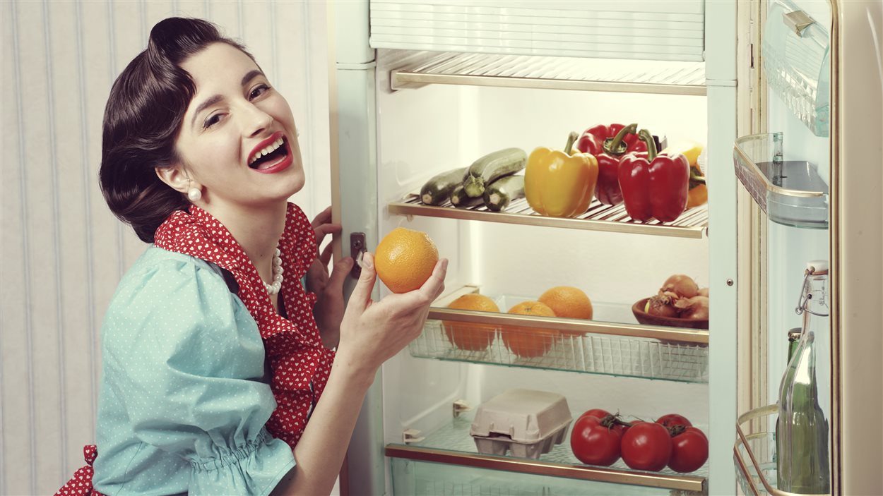Femme devant un réfrigérateur des années 1950. 