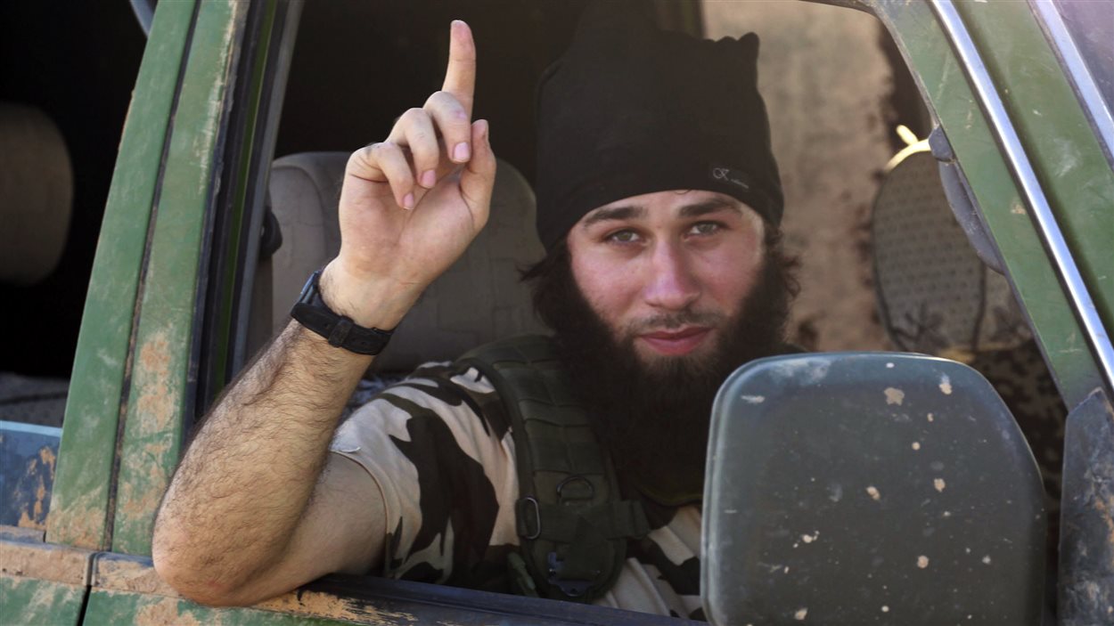 Un djihadiste de l'État islamique fait un geste de victoire dans une rue de Kobané.