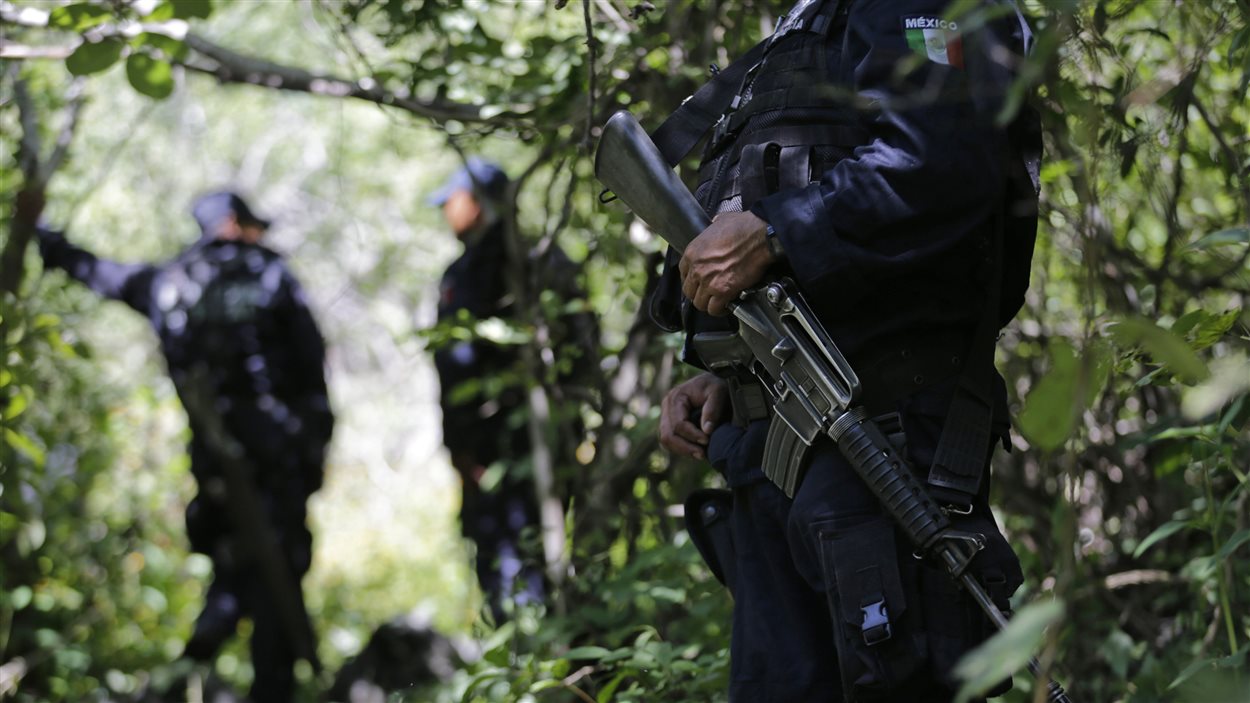 Des policiers mexicains montent la garde près d'une fosse commune