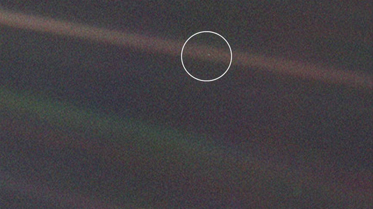 Image prise par la sonde Voyager 1 en 1990. Au centre du cercle blanc, on voit la Terre.