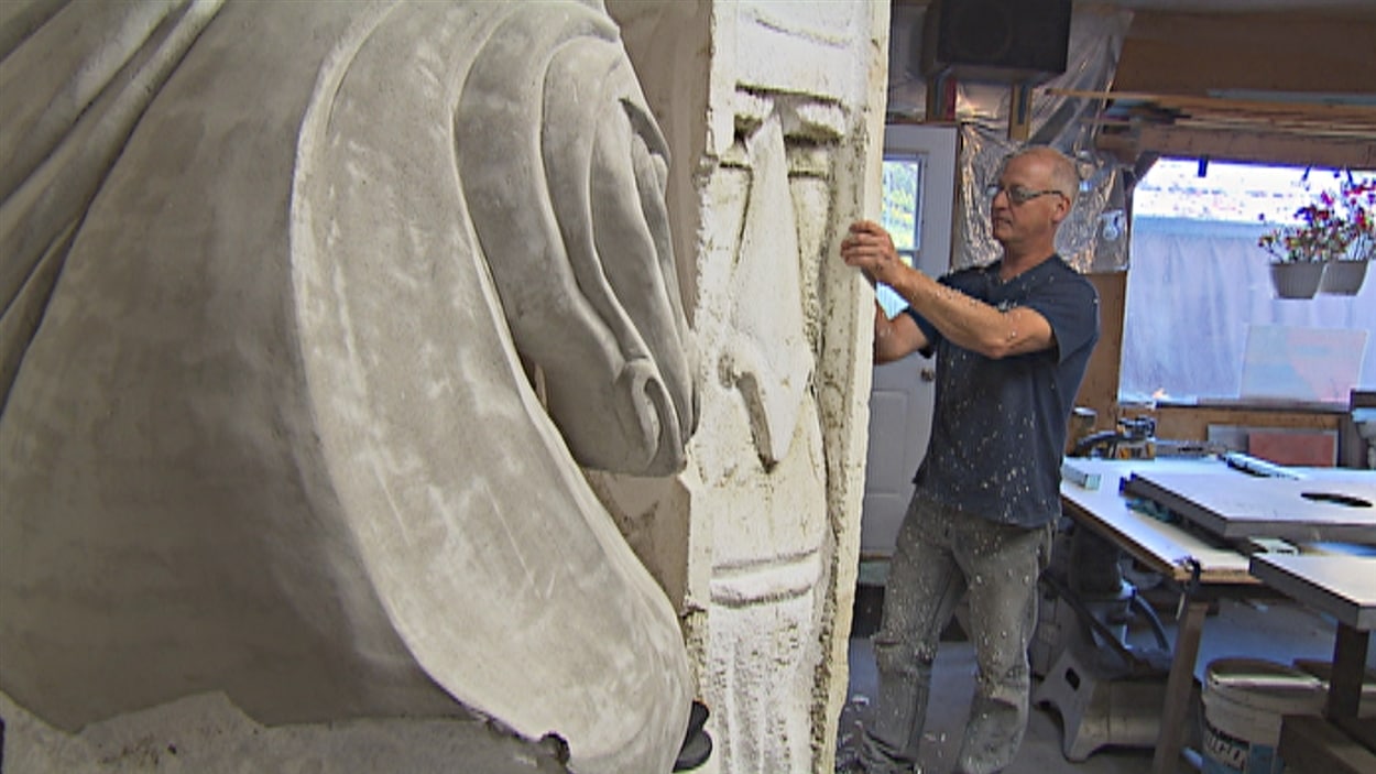 Sylvain Bolduc en train de façonner une statue monumentale dans un bloc de styromousse