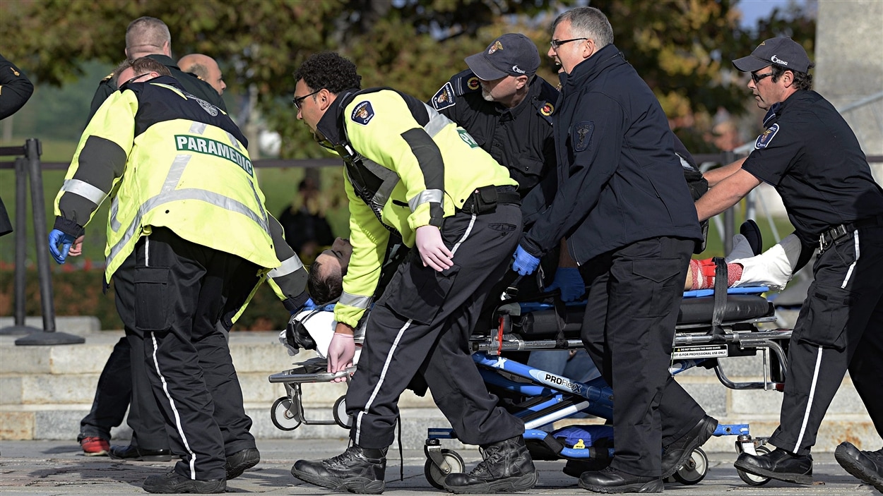 Des ambulanciers transportent un blessé au Monument commémoratif de guerre du Canada, à Ottawa.