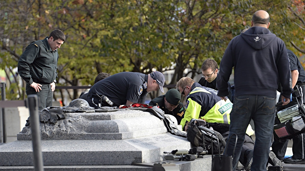 Des ambulanciers paramédicaux traitent un blessé au Monument commémoratif de guerre du Canada, rue Elgin, à Ottawa.
