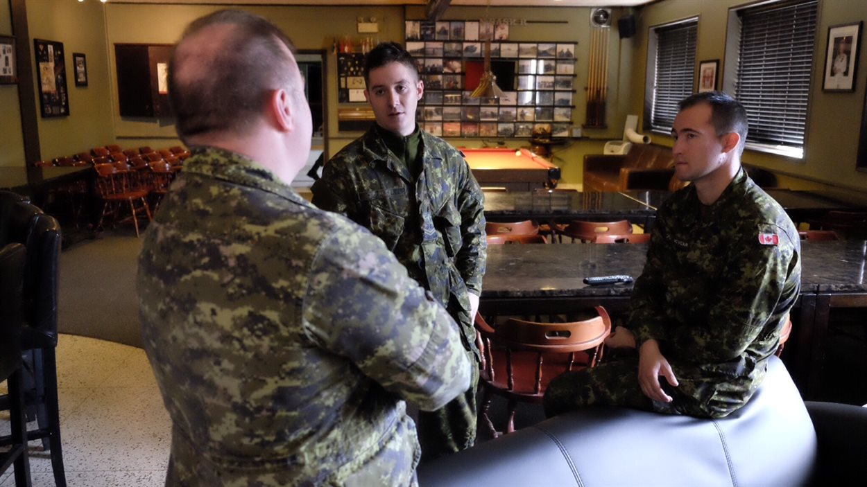 Le lieutenant-colonel Tony Engelberts discute avec deux des 300 réservistes présents au manège militaire sgt Hugh Cairns à Saskatoon.