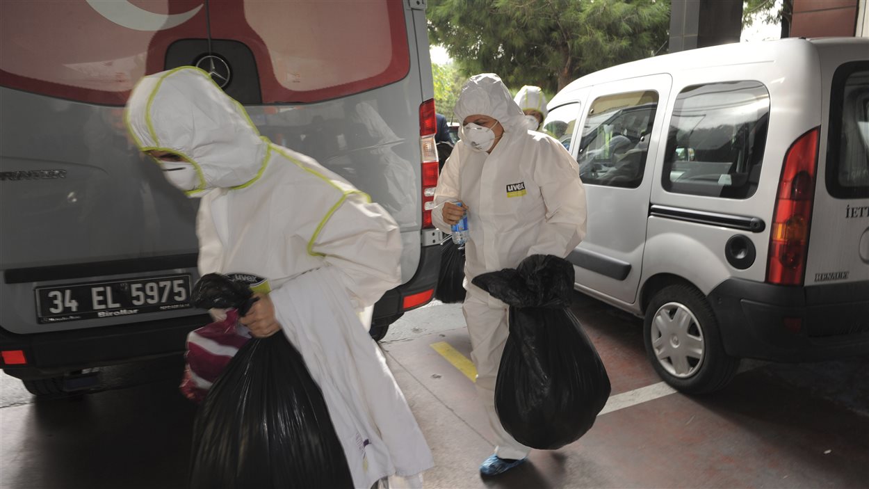 Des membres d'une unité de décontamination turque transportent des sacs contenant des effets provenant du consulat canadien, à Istanbul, le 24 octobre.