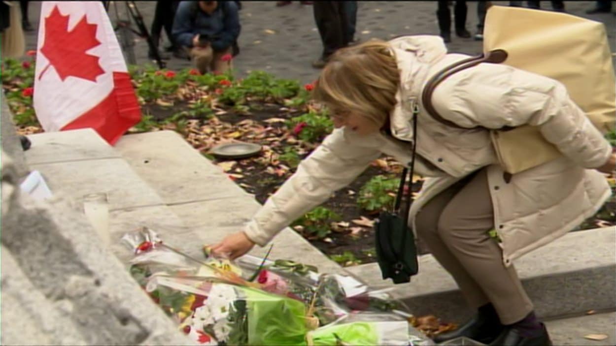 Une passante dépose des fleurs en hommage aux deux soldats tués cette semaine.