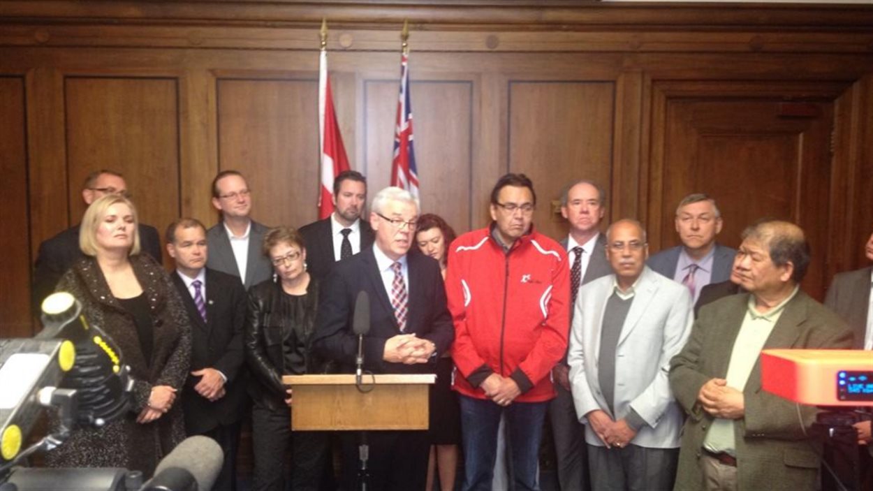 Le premier ministre du Manitoba, Greg Selinger, entouré par des membres du Nouveau parti démocratique.