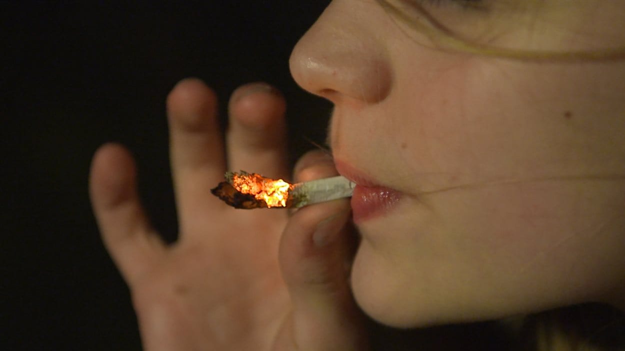 Jeune fille fumant de la marijuana