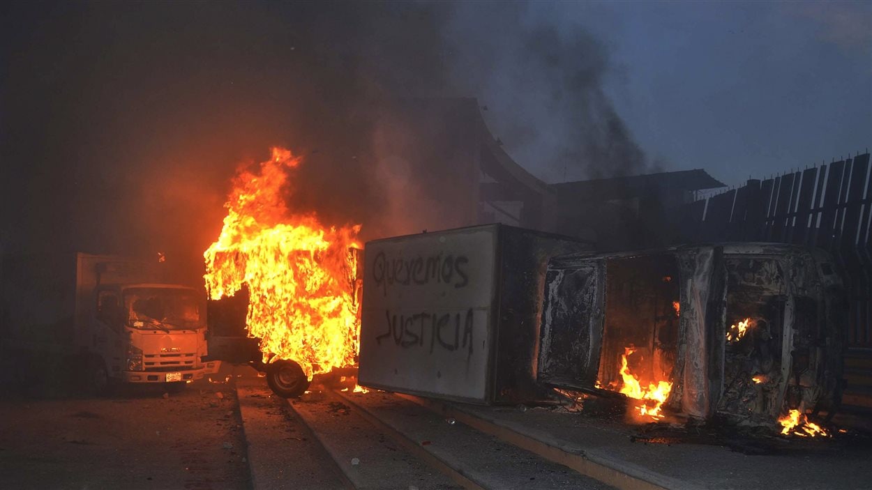 « Nous voulons la justice » écrit sur un des véhicules incendiés devant le siège du gouvernement régional de l'État du Guerrero.