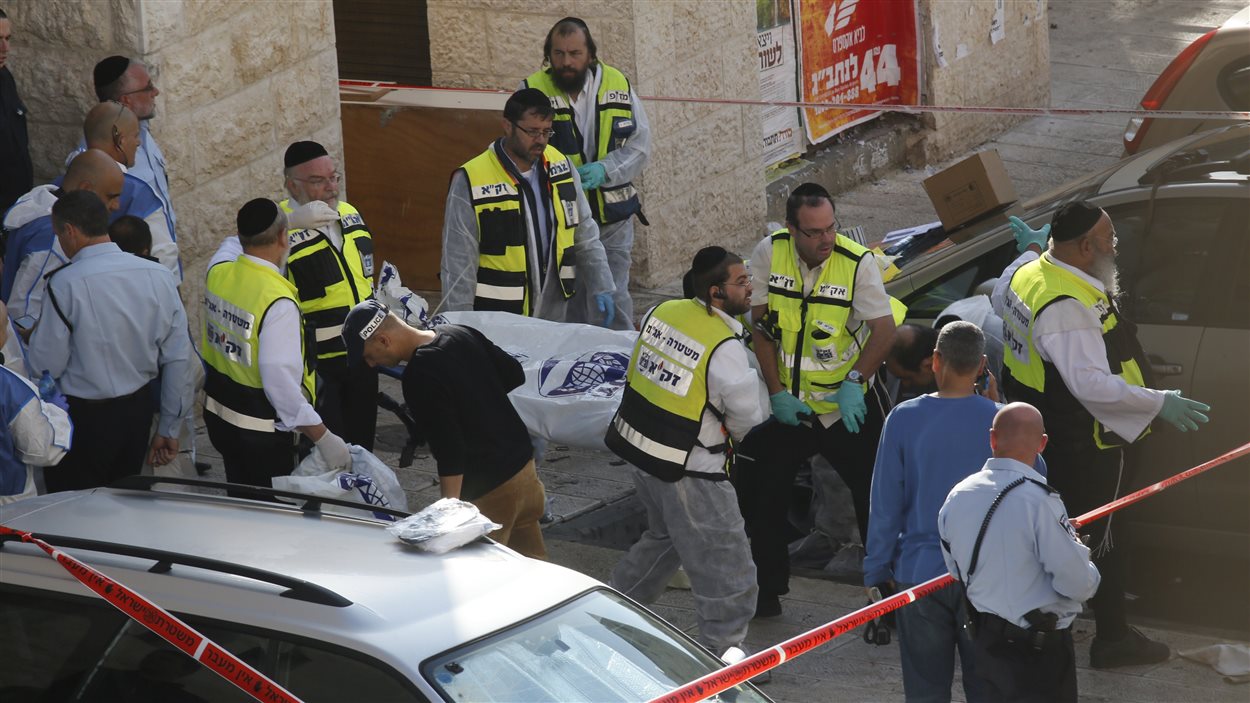 Les secours israéliens transportent le corps d'un des assaillants palestiniens d'une synagogue de Jérusalem, abattu par les policiers.