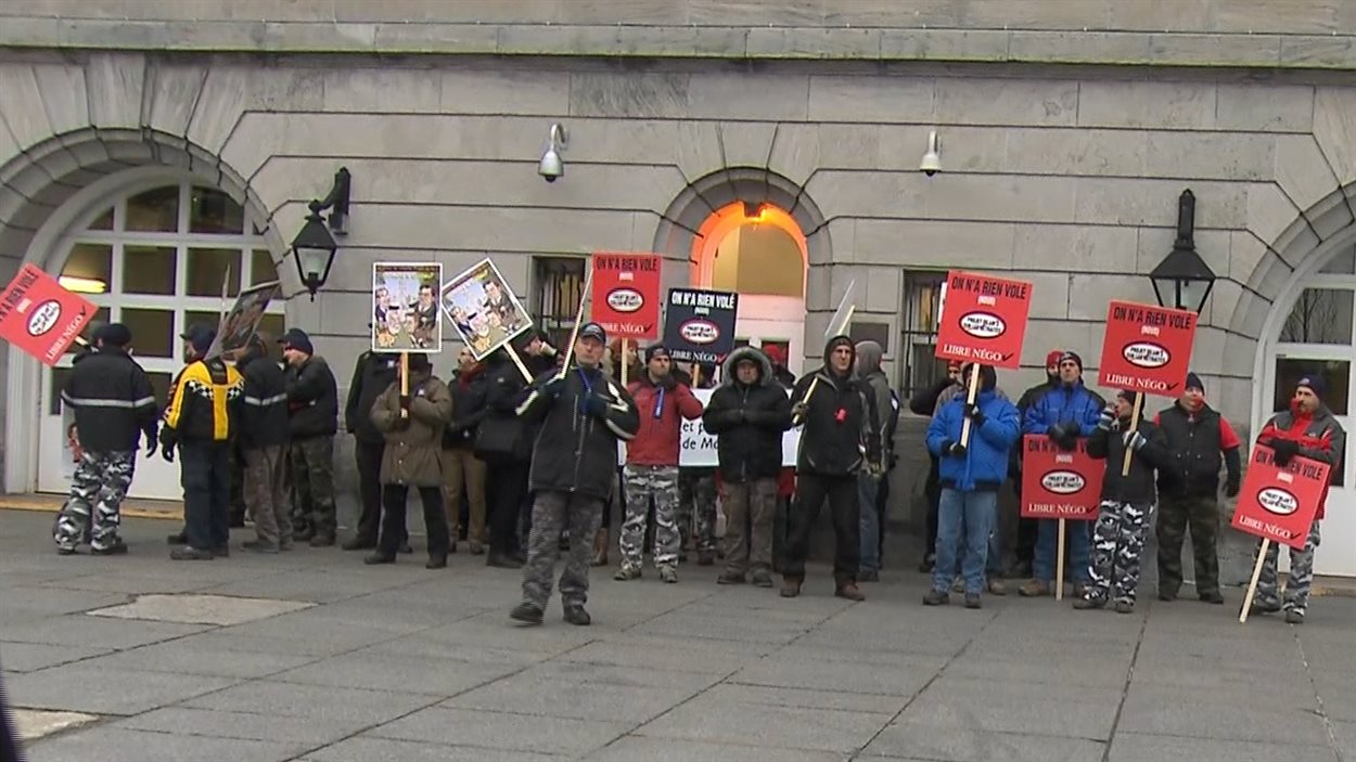Des manifestants bloquent une entrée à l'hôtel de ville de Montréal.