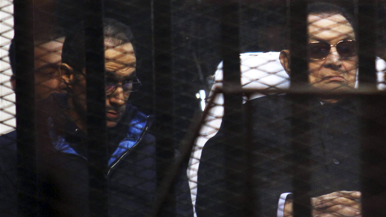L’ancien président égyptien Hosni Moubarak (à droite) et son fils  Jamal  (à gauche) dans le box des accusés à l’académie de police où s’est déroulé le procès.