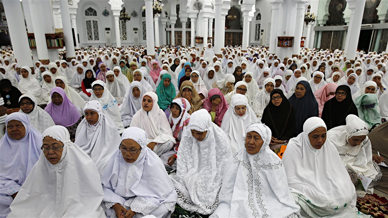 Des Indonésiennes prient dans la mosquée qui avait été l'un des rares immeubles à demeurer quasi-intact lors du passage du tsunami, il y a 10 ans, à Banda Aceh.