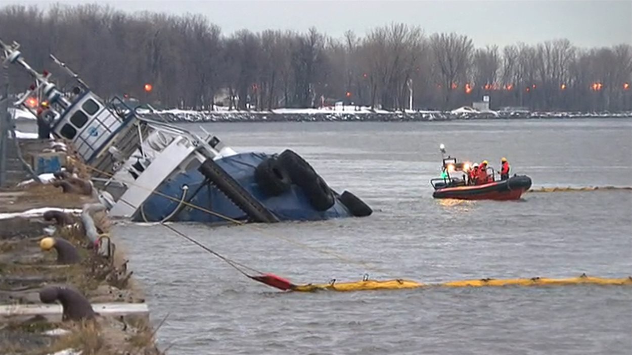Urgence-Environnement tente de contenir les 22 tonnes de carburant qui s'échappent du bateau-remorqueur ayant sombré à Trois-Rivières, vendredi.