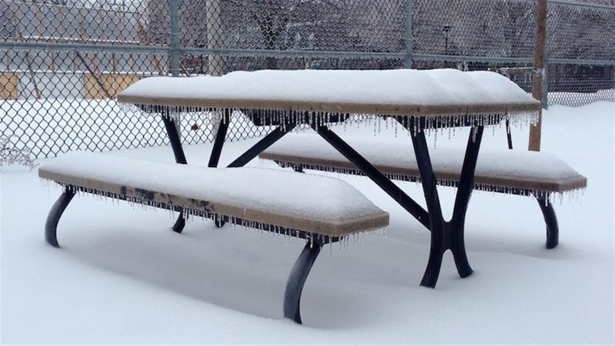 Un banc enneigé et gelé à Montréal après la première tempête de neige de l'année 2015.