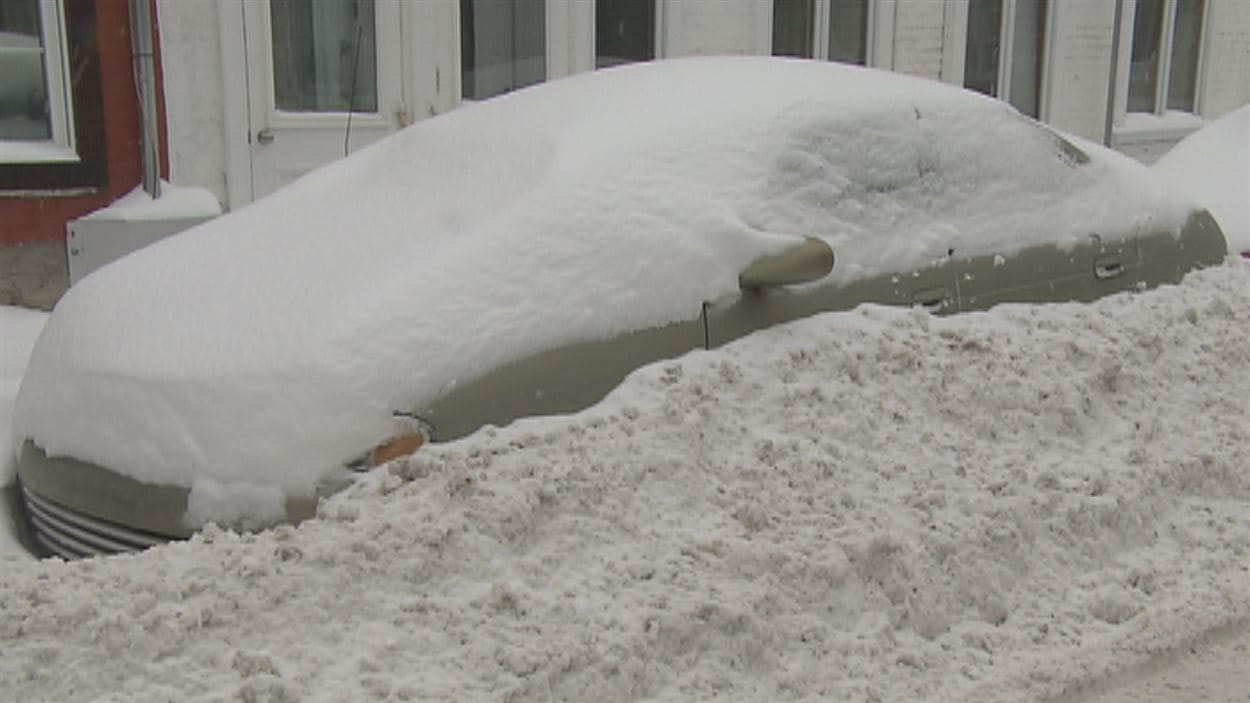 Une voiture ensevelie sous la neige dans le quartier Saint-Jean-Baptiste, à Québec.
