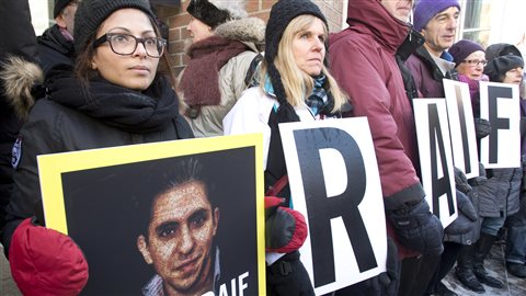 La femme de Raif Badawi, Ensaf Haidar, tient une photo de son mari lors d'une manifestation pour demander sa libération le 13 janvier 2015, à Montréal.  