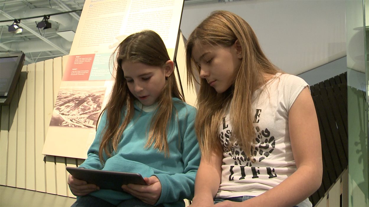 Deux élèves consultent l'application mobile du Musée de la Gaspésie.