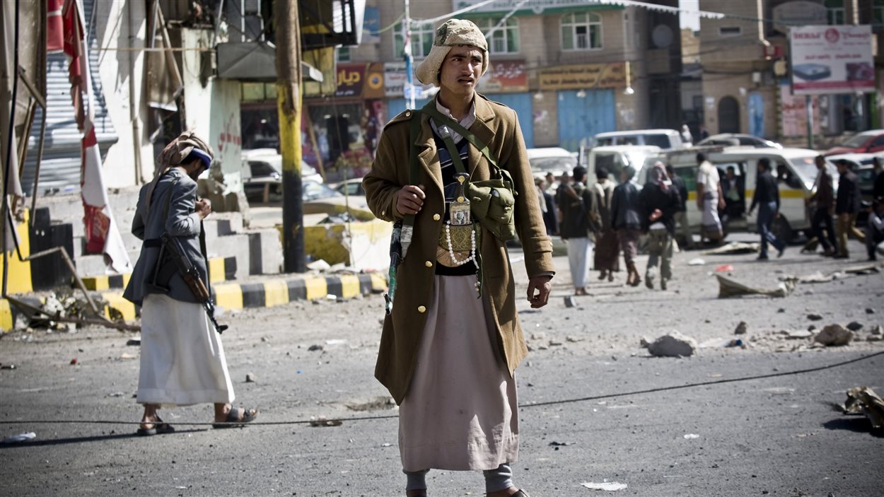 Un milicien chiite monte la garde sur la route qui mène au palais présidentiel, à Sanaa.