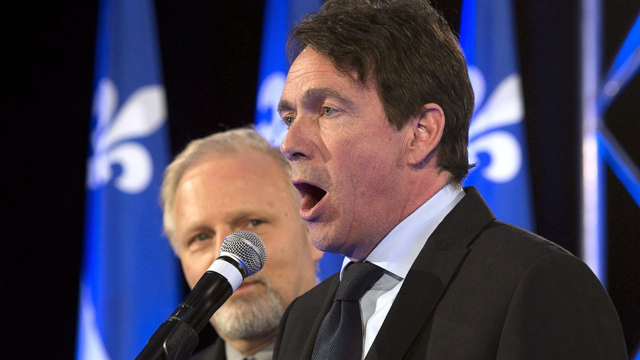 Pierre Karl Péladeau s'adresse aux militants après la cuisante défaite du Parti québécois le 7 avril 2014. À l’arrière, le député Jean-François Lisée.