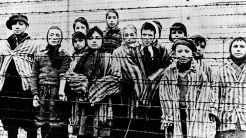 Photo prise juste après la libération du camp de concentartion Auschwitz-Birkenau par l'armée soviétique en janvier 1945. La fille qui montre le tatouage de son numéro de matricule est Miriam Ziegler.