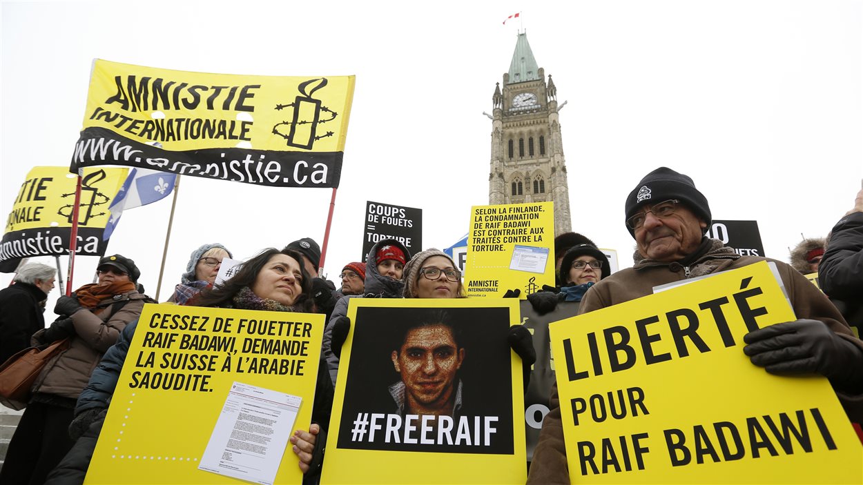 La femme de Raif Badawi, Ensaf Haidar, tient une photo de son mari lors d'une manifestation à Ottawa.