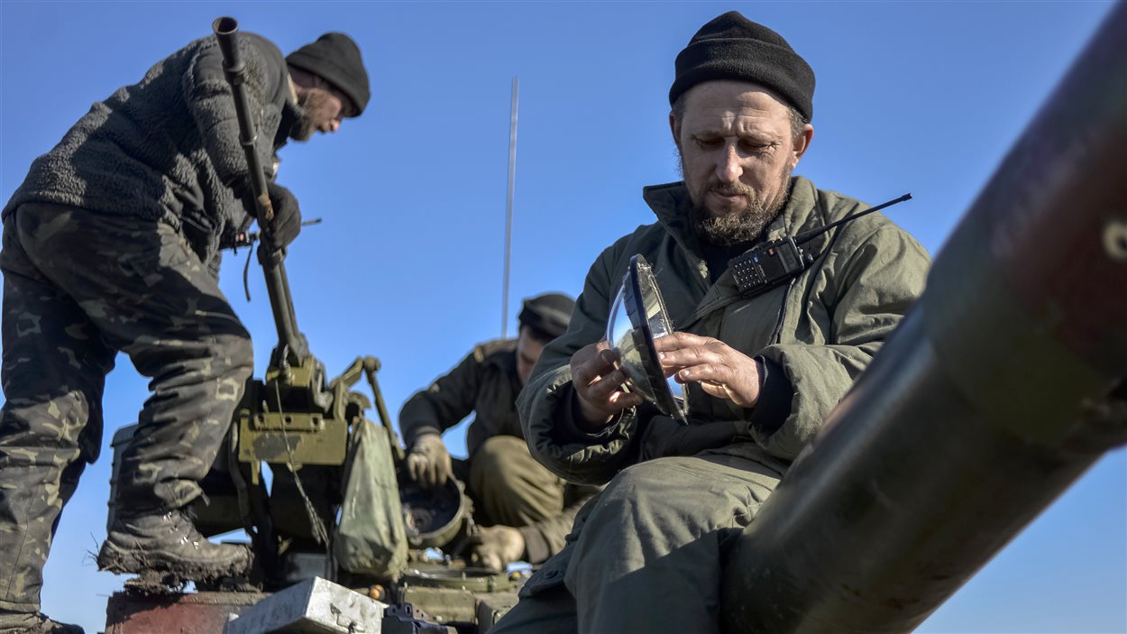 Des soldats ukrainiens s’occupent de leur équipement sur un char d’assaut à Donetsk.